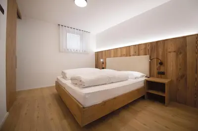 a bedroom with a bed with a wooden wall at Living Miramor in Racines