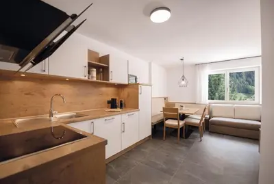 a kitchen with a sink and a table and a couch at Living Miramor in Racines