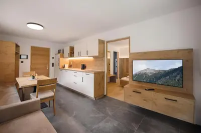 a kitchen with a large tv on the wall at Living Miramor in Racines