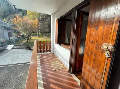 an open door of a house with a porch at Appartamento La Casa di Violetta in Tonadico