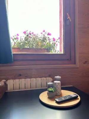 a table with a remote control and a window at Perla Dolomiti Falt in Falcade