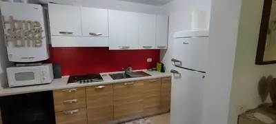 a kitchen with white cabinets and a white refrigerator at Alessandro's Home in Carano