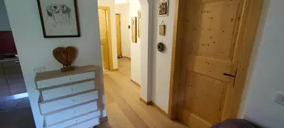 a hallway with a wooden door and a dresser in a room at Alessandro's Home in Carano