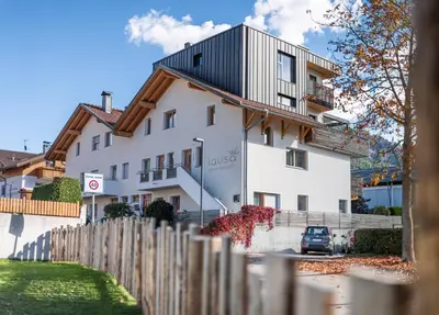 a white house with a black roof at Small Luxury Apartments Lausa in Valdaora