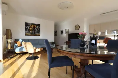 a living room with a table and a couch at Luxus Penthouse mit Terrasse, Garage, Fahrradraum und Infrarotsauna in Merano