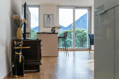a room with a table with a mirror and windows at Luxus Penthouse mit Terrasse, Garage, Fahrradraum und Infrarotsauna in Merano