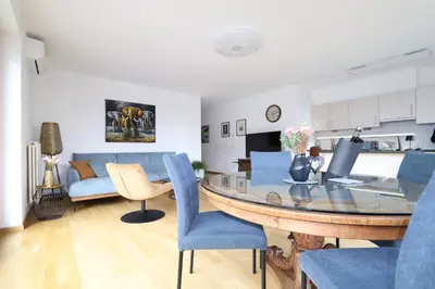 a living room with a table and blue chairs at Luxus Penthouse mit Terrasse, Garage, Fahrradraum und Infrarotsauna in Merano