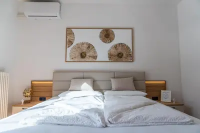 a bedroom with a bed with two pillows at Luxus Penthouse mit Terrasse, Garage, Fahrradraum und Infrarotsauna in Merano