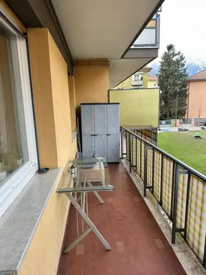 a balcony with a glass table on the side of a building at Appartamento Vacanze in Merano