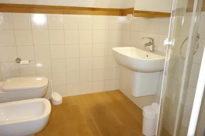 a white bathroom with a toilet and a sink at Villa Molteni, Ville di Fiemme, Varena in Varena