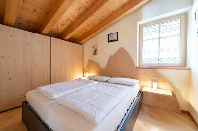 a large bed in a room with a window at Cesa Antermoia in Mazzin