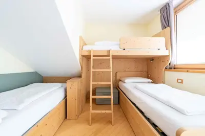 a small room with two bunk beds and a ladder at Cesa Antermoia in Mazzin
