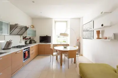 a kitchen with a table and a dining room at Victoria Apartment in Bolzano