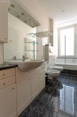 a bathroom with two sinks and two toilets at Victoria Apartment in Bolzano