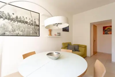 a white dining room with a white table and chairs at Victoria Apartment in Bolzano