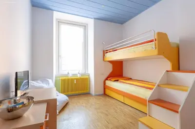 a room with two bunk beds and a desk at Victoria Apartment in Bolzano