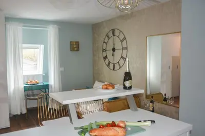 a kitchen with a table and a clock on the wall at moderne Ferienwohnung in Merano