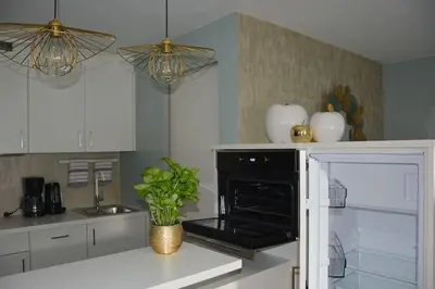a kitchen with white cabinets and a black oven at moderne Ferienwohnung in Merano