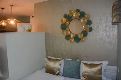 a room with a mirror and a couch with pillows at moderne Ferienwohnung in Merano