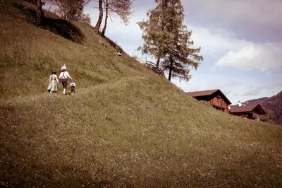 two people walking up a hill with a dog at Unterweg Hof in Sarntal