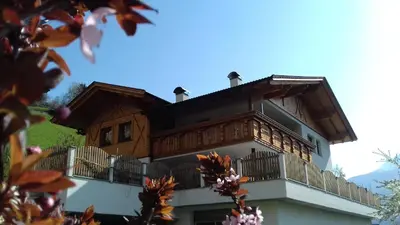 a building with a wooden roof and a balcony at Unterweg Hof in Sarntal