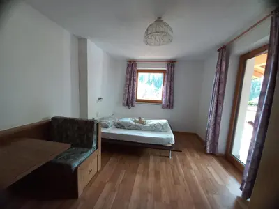 a bedroom with a bed and a window at Unterweg Hof in Sarntal