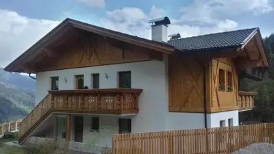 a house with a wooden balcony on top of it at Unterweg Hof in Sarntal
