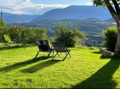 two chairs sitting on top of a field of grass at San Antonia in Caldaro