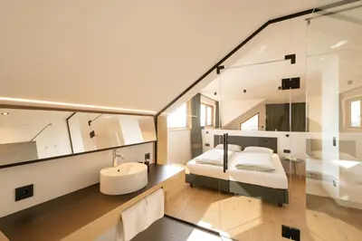a glass house with a bed and a sink at San Antonia in Caldaro