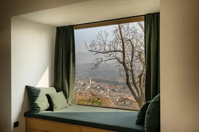 a window seat with a view of a city at San Antonia in Caldaro