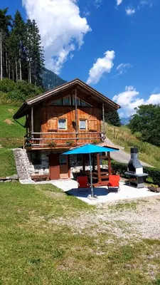 a building with a table and chairs in front of it at Maso Brunetto in Canale San Bovo