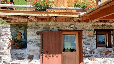 a stone building with a door and a window at Maso Brunetto in Canale San Bovo