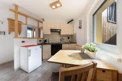 a kitchen with a wooden table and a white refrigerator at CASA PARE' B&B in Tesero