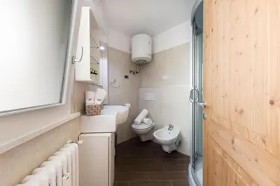 a small bathroom with a toilet and a sink at CASA PARE' B&B in Tesero