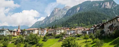 a village in the mountains with houses and trees at CASA PARE' B&B in Tesero