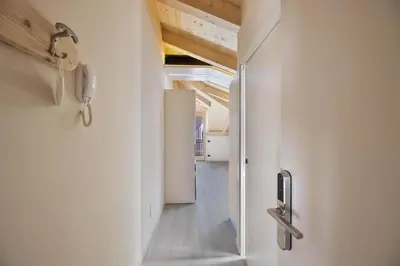 a hallway with white walls and a door to a room at CASA PARE' B&B in Tesero