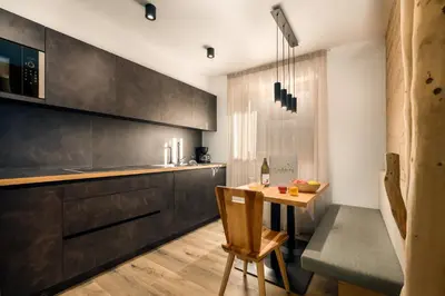 a kitchen with a wooden table and a dining room at Neuhuberhof in Vols am Schlern