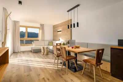 a kitchen and living room with a table and chairs at Neuhuberhof in Vols am Schlern