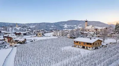 a town with a bunch of vineyards in the snow at Neuhuberhof in Vols am Schlern