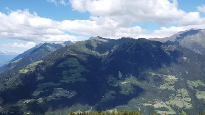 a view of a mountain range with clouds in the sky at Portnerhof auf Oberkirn in Schenna