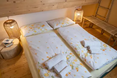 a bed in a room with two pillows on it at Ciasa Gianot - Shin in Moena