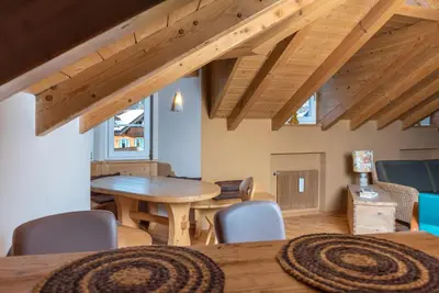 a living room with a wooden table and chairs at Ciasa Gianot - Shin in Moena