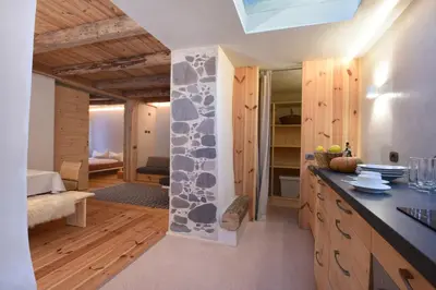 a kitchen with a stone wall in a house at B&B Mas de Lagorae in Tesero