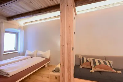 a bed in a room with a wooden pole at B&B Mas de Lagorae in Tesero