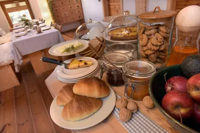a table topped with plates of bread and other foods at B&B Mas de Lagorae in Tesero