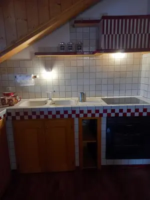 a kitchen with a sink and a stove at Deliziosa mansarda con vista Dolomiti in San Vito di Cadore