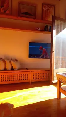 a living room with a tv on the wall at Deliziosa mansarda con vista Dolomiti in San Vito di Cadore