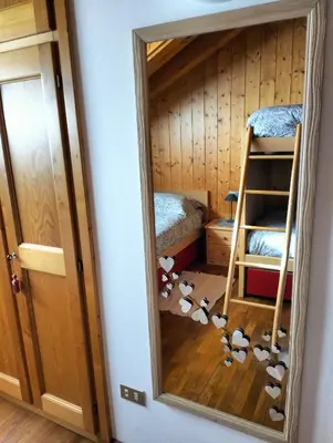 a mirror in a room with a bunk bed and a ladder at Deliziosa mansarda con vista Dolomiti in San Vito di Cadore