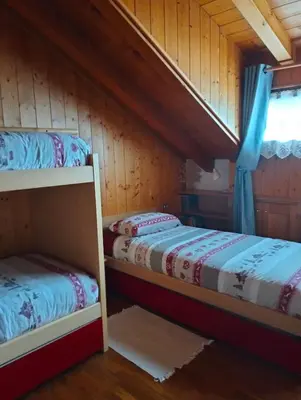 a room with two bunk beds in a cabin at Deliziosa mansarda con vista Dolomiti in San Vito di Cadore