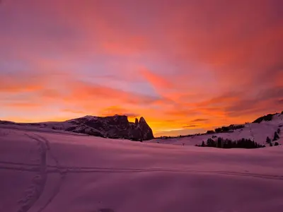 a sunset in the snow with a mountain in the background at Salmsein Biohof in Fiè